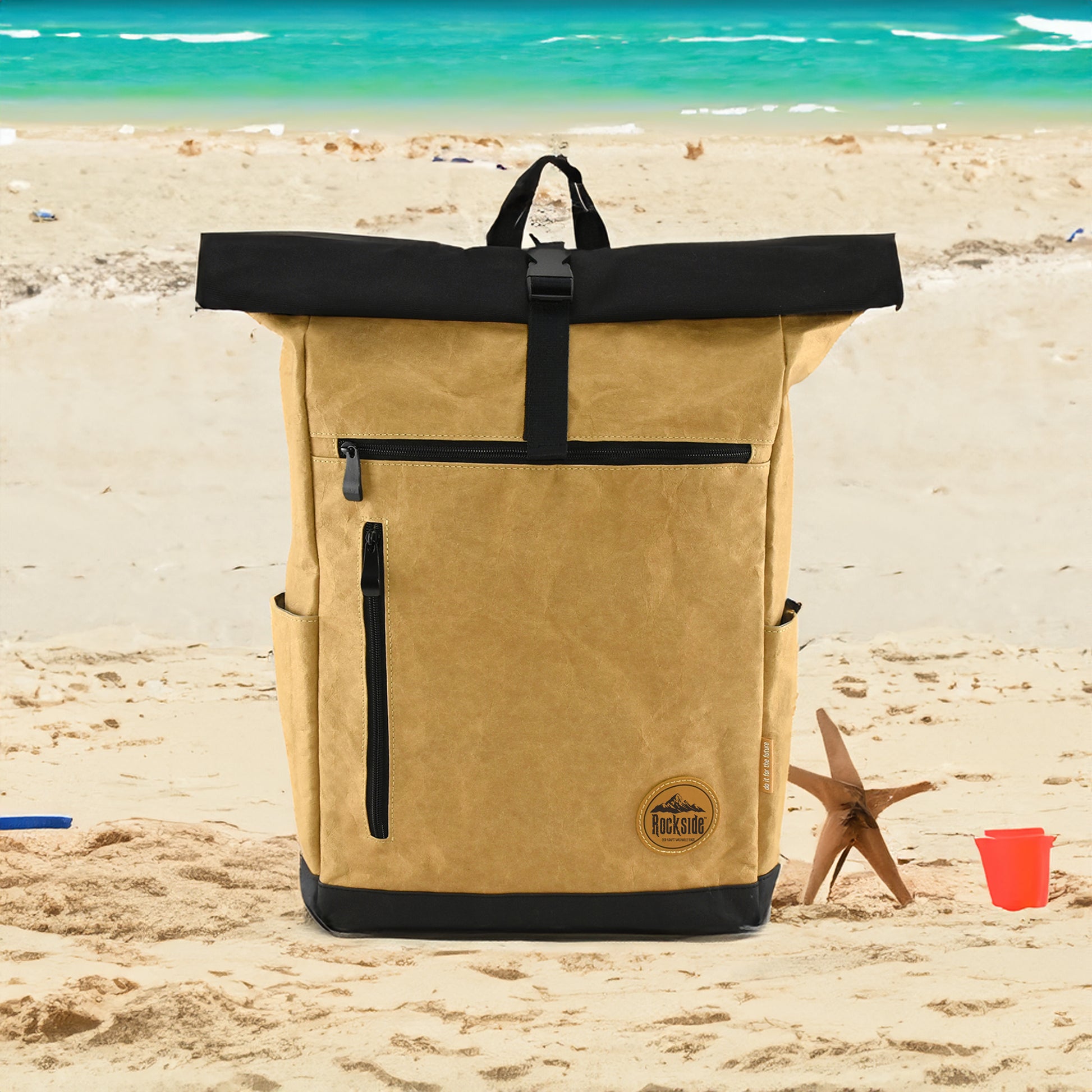 Seaside Kraft Paper Laptop Backpack shown on a beach, highlighting its eco-friendly design and durable construction in a natural outdoor setting.